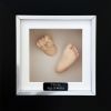 104- flesh colour casts in black & silver frame on white backing