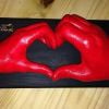 70- Red heart shaped hand cast on black wooden plinth