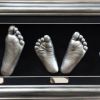 16- silver feet casts in silver frame with black backing & mount